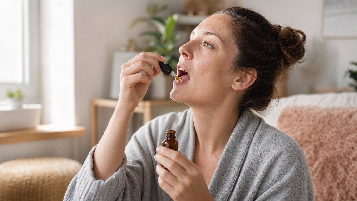 Person holding a CBD tincture dropper to their mouth in soft morning light