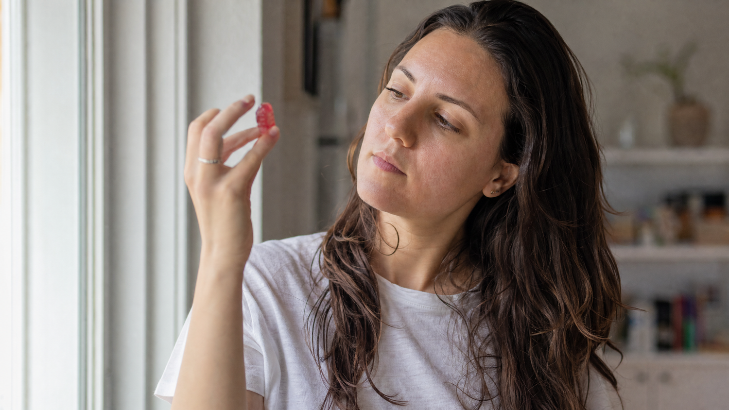 Person examining a THCV gummy in natural light